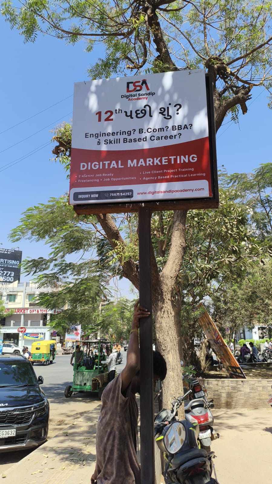 True Business Times team installing a large illuminated sign board in Ahmedabad